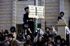 Ultra-Orthodox Jewish men gather around a sign that reads in Hebrew: ‘Women are asked not to linger in this area’ outside a synagogue in Beit Shemesh on Monday. Ultra-Orthodox Jewish men gather around a sign that reads in Hebrew: ‘Women are asked not to linger in this area’ outside a synagogue in Beit Shemesh on Monday.